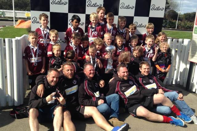 Melton RFC Under 9s players and coaching staff show off their Tigers Challenge trophy EMN-160305-123605002