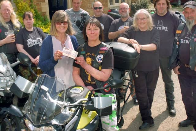 The Crown licensee Anna Edmonds accepts the cheque from Druids Motorcycle Club member Fiona Gray and fellow bikers PHOTO: Tim Williams
