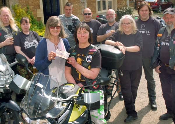 The Crown licensee Anna Edmonds accepts the cheque from Druids Motorcycle Club member Fiona Gray and fellow bikers PHOTO: Tim Williams