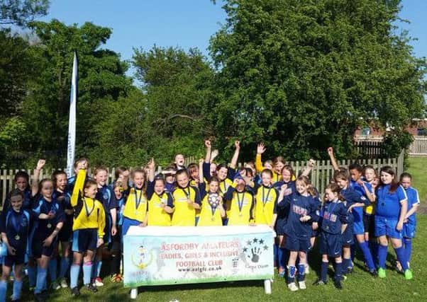 Players celebrate a successful girls' school football league EMN-160519-170547002