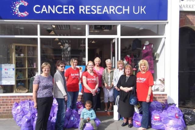 Melton Slimming World consultants and members with Cancer Research UK shop manager Eva Pone and a shop volunteer. EMN-160521-095432001