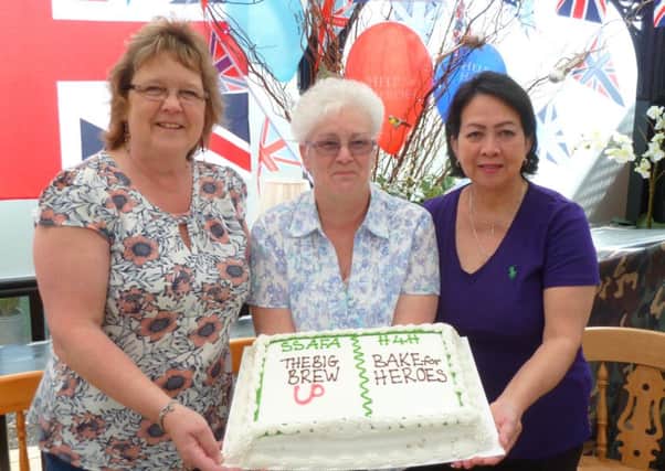 Holding the cake are, from left, Carol Varnham, Sue Dickinson and Jenny Foley EMN-160525-095811001