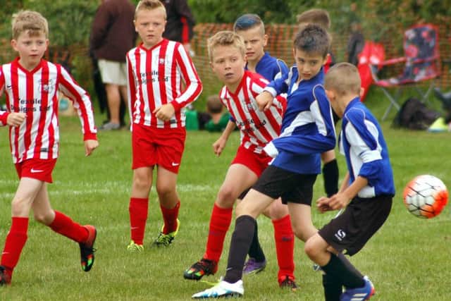 Asfordby Colts Under 9s (in blue kit) in match action at their home tournament EMN-160615-092947002