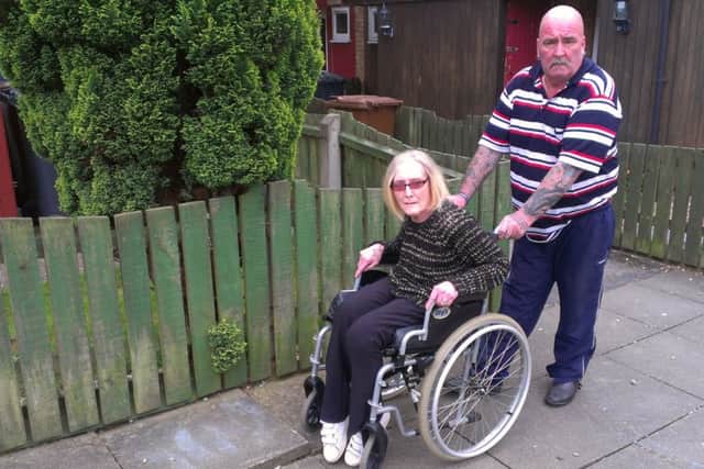 Wheelchair-bound Melton Council tenant Karen Knight with her husband and carer Paul on the path outside their home on Drummond Walk EMN-160806-152222001