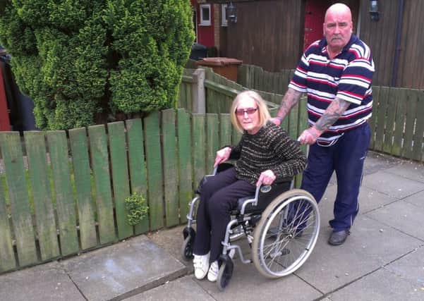 Wheelchair-bound Melton Council tenant Karen Knight with her husband and carer Paul on the path outside their home on Drummond Walk EMN-160806-152222001