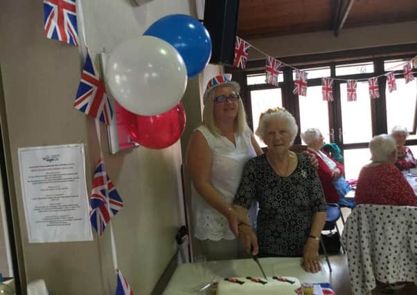 Queen for the day Gladys Huddlestone cuts the cake alongside Resource centre Manager Rhonda Fazackerley 
PHOTO: Supplied