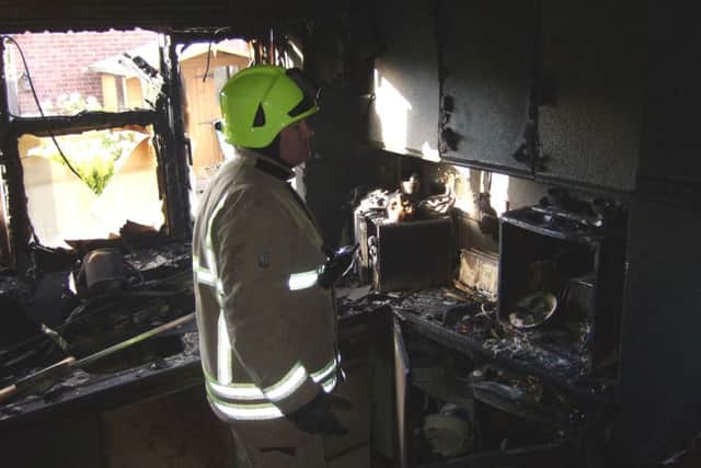 Firefighter Nick Spargo inspects the damage in Mr Bielski's kitchen following the blaze EMN-160620-111033001