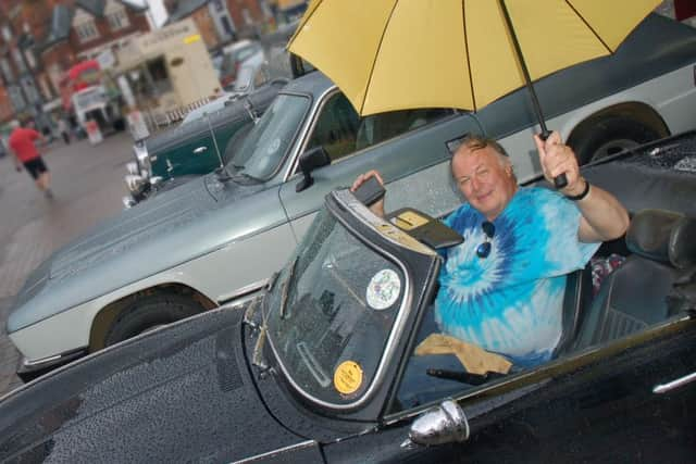 Andrew Lee takes shelter in his 1968 Triumph Spitfire 
PHOTO: Tim Williams