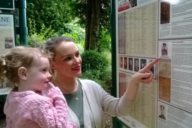 Celina Lucas and her three-year-old daughter, Darcie, view the information about Celina's great great uncle, Sgt Robert Orton, displayed on one of the interpretation boards EMN-160628-190133001