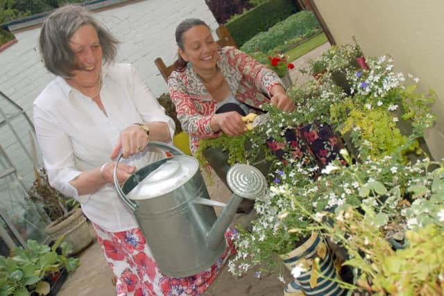 Alison Blythe and gardener Christina Moulton tend to some ornamental welly boots at the open garden event
PHOTO: Tim Williams