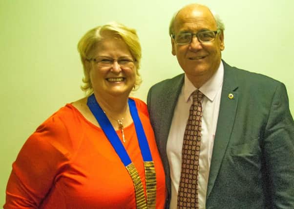 Outgoing president of the Melton Mowbray Lions Club, John Illingworth has handed over the chain of office to his successor Sabrina Tate PHOTO: Supplied
