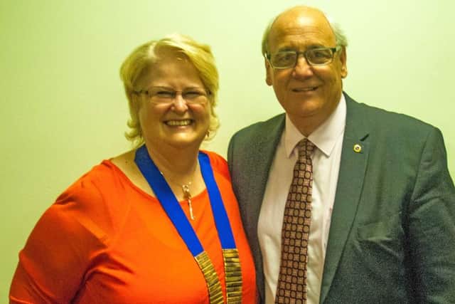 Outgoing president of the Melton Mowbray Lions Club, John Illingworth has handed over the chain of office to his successor Sabrina Tate PHOTO: Supplied