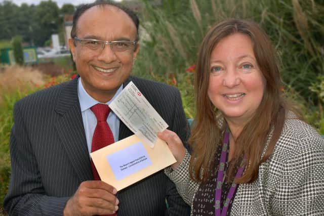 Chief executive of Leicestershire and Rutland Emmaus Mir Juma accepts cheque from former Melton Mayor Jeanne Douglas
PHOTO: Tim Williams