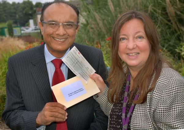 Chief executive of Leicestershire and Rutland Emmaus Mir Juma accepts cheque from former Melton Mayor Jeanne Douglas 
PHOTO: Tim Williams