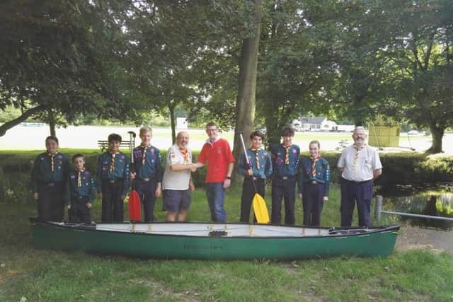 Richard Westmoreland, chairman of Melton Mowbray Round Table (centre), presents the Melton Mowbray 4th Scout Group with one of the canoes from the race
PHOTO: Supplied
