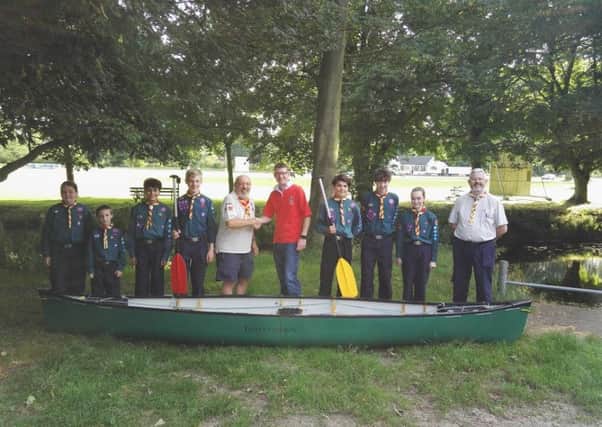 Richard Westmoreland, chairman of Melton Mowbray Round Table (centre), presents the Melton Mowbray 4th Scout Group with one of the canoes from the race 
PHOTO: Supplied