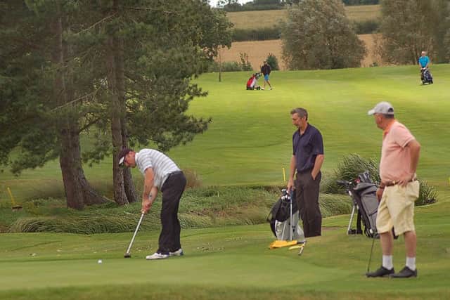 After battling windy conditions the first group finally reach the 18th green PHOTO: Tim Williams