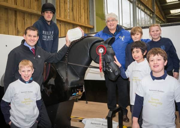 Joseph Platt rides Jet, the new mechanical horse at The Mount Group riding school for the disabled at Somerby, with Samworth Brothers Sports Opportunity Fund trustee Tim Barker (left), Mount Group trustee Pat Bishop and children from Knossington Grange School and Oakham CE Primary Schooll EMN-160825-135339002