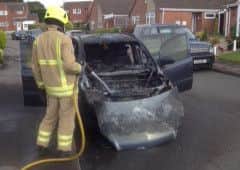 A firefighter damping down after the car fire EMN-160919-174943001