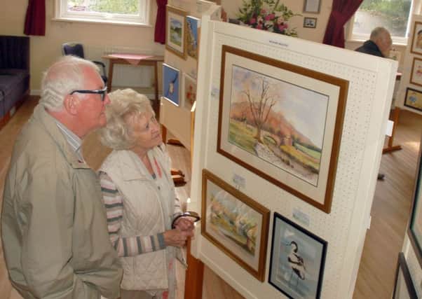 Local artist Maggie Pope and husband Ernie admire the artwork on display PHOTO: Tim Williams