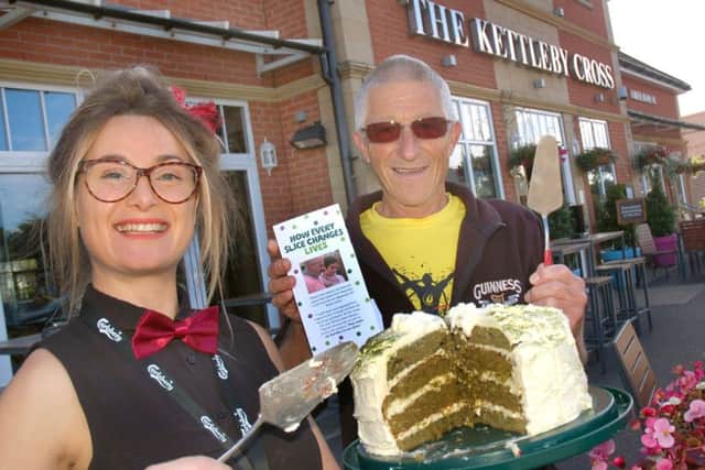 Kettleby Cross regular David Newton looks pleased with his cake portion served by bar associate Samantha Batten. The day raised Â£130 PHOTO: Tim Williams