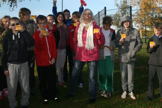 Birch Wood pupils are given purple crocus lapel badges by Christine Vernon from the Rotary Club of Melton Aurora PHOTO: Supplied