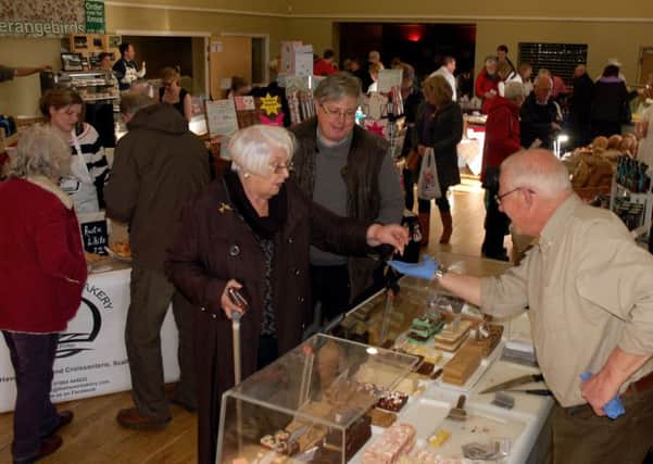 Food lovers try some samples as they make their way around the village hall event PHOTO: Tim Williams