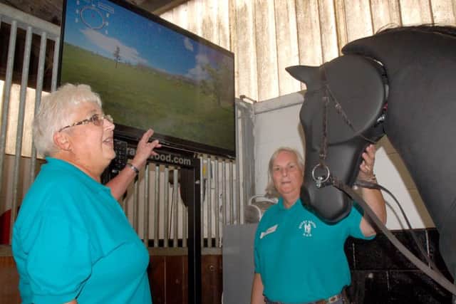 Pat Bishop and fellow RDA volunteer Judy Jennings with the dressage simulator, affectionately known as Robocob EMN-161011-111601002