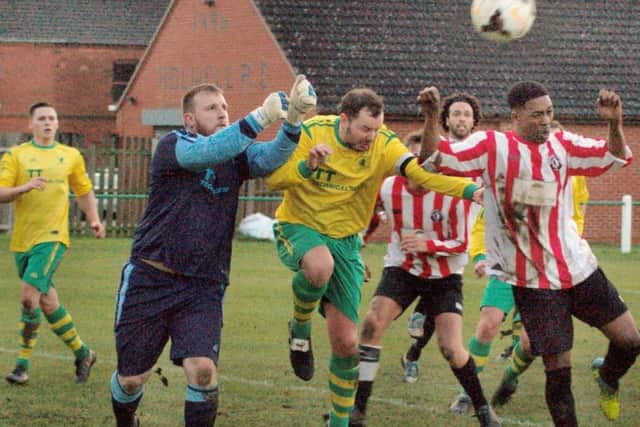Holwell keeper Jamie Witham and captain Aaron Ridout attempt to clear the danger EMN-161121-160654002