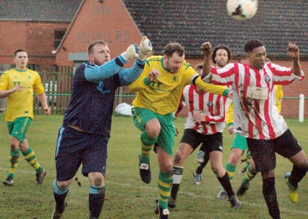 Holwell keeper Jamie Witham and captain Aaron Ridout attempt to clear the danger EMN-161121-160654002