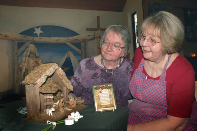 Margaret Phillips and Jen Hanson admire the Macmillan nativity scene PHOTO: Tim Williams EMN-160811-162450001