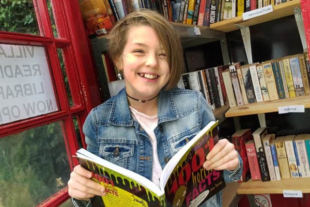 11-year-old Aisling Giltinan calls in for a read at the new Stathern phone box library in the village EMN-161128-125934001
