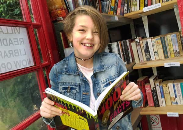 11-year-old Aisling Giltinan calls in for a read at the new Stathern phone box library in the village EMN-161128-125934001