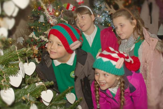 Frisby School pupils Thomas Pearson, Ruby Lauton, Georgina Bailey and Alice Williams take a close look at one of the festive creations PHOTO: Tim Williams