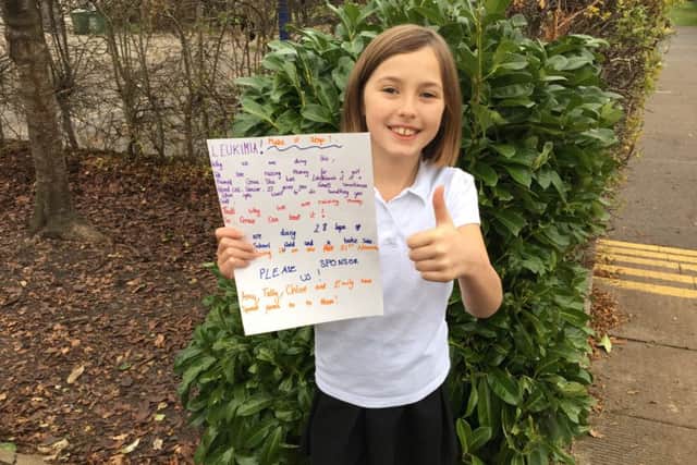 Chloe with one of her posters she put up around school PHOTO: Supplied