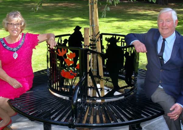 Melton Town Estate feoffee John Southerington and Senior Townwarden Dinah Rudman sit on the new commemorative seat in the town's Memorial Gardens EMN-161228-095202001