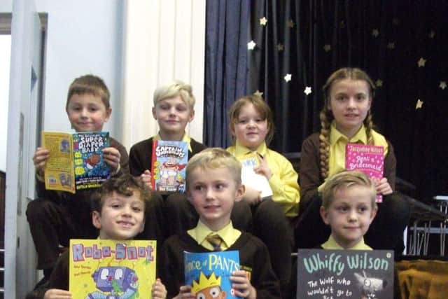 Children at St Francis show off their books given to them by the school's book elf PHOTO: Supplied