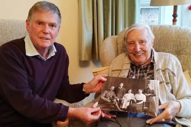 Peter Radford (right) with his cousin Mick holding a family photo showing Fred Radford EMN-170117-184940001
