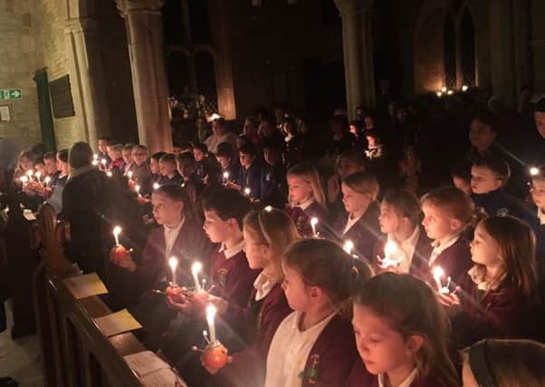 Children from both schools light up the church with their Christingle oranges PHOTO: Supplied