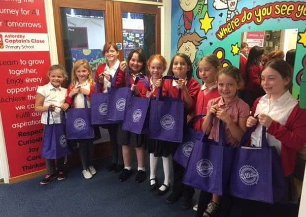 The girls show off their Wilton baking bags after taking part in the school bake-off challenge PHOTO: Supplied