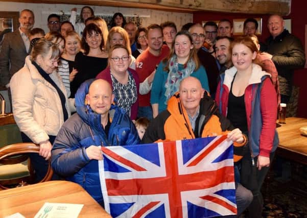 Amateur mountaineers Chris Foster (front left) and Ian Beale with their summit flag and friends and family at their send-off party at the Crown and Plough, Long Clawson, before they flew out to Argentina to climb Mount Aconcagua EMN-170130-104132001