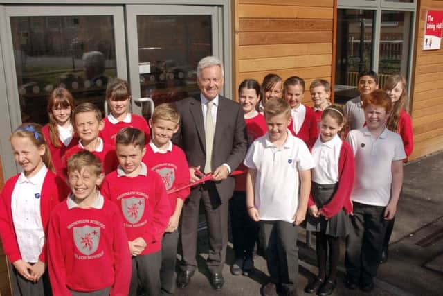 Melton MP Sir Alan Duncan cuts a ribbon to officially open Browlow School's new dining hall EMN-150925-162935001