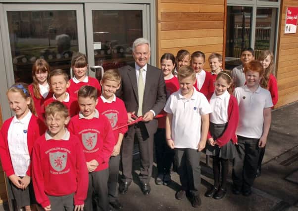 Melton MP Sir Alan Duncan cuts a ribbon to officially open Browlow School's new dining hall EMN-150925-162935001