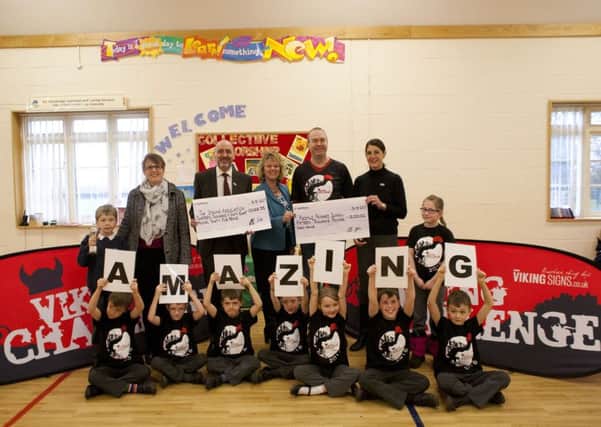 Colin Shearer, chairperson of the Viking Challenge Committee (2nd from right), presents Redmile head teacher Julie Hopkins (centre), and Paul Lawless and Louise Knight (right) members of the Stroke Association, with their cheques. Also pictured are children from Redmile School and Helen Snow (2nd from left), for the Peter Snow Award which was awarded to Mark Beeston. His son Max accepted on his father's behalf PHOTO: Supplied