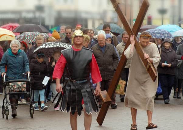 Tom Styles plays the part of Jesus accompanied by the Roman Centurians and congregation, making their way to the short service in Market Place PHOTO: Tim Williams