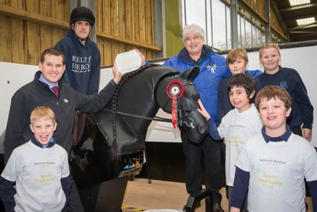 Joseph Platt rides Jet, the new mechanical horse at The Mount Group riding school for the disabled at Somerby, with Samworth Brothers Sports Opportunity Fund trustee Tim Barker (left), Mount Group trustee Pat Bishop and children from Knossington Grange School and Oakham CE Primary Schooll EMN-170425-171844001