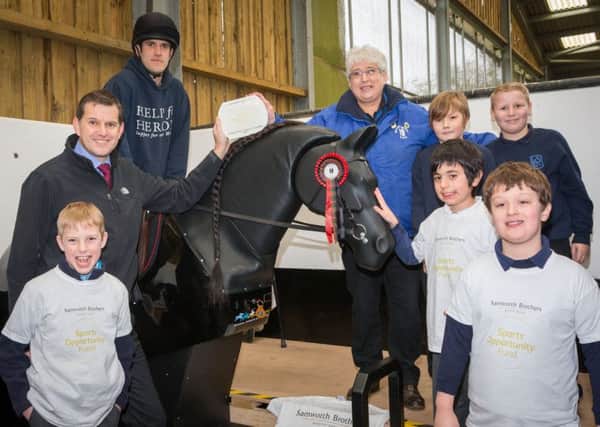 Joseph Platt rides Jet, the new mechanical horse at The Mount Group riding school for the disabled at Somerby, with Samworth Brothers Sports Opportunity Fund trustee Tim Barker (left), Mount Group trustee Pat Bishop and children from Knossington Grange School and Oakham CE Primary Schooll EMN-170425-171844001