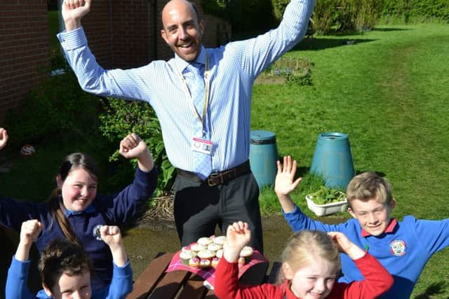 Ab Kettleby Primary School head teacher Ian Toon celebrates with pupils after the school received a 'good' Ofsted rating EMN-170428-122659001