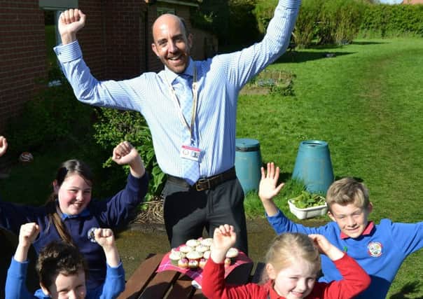 Ab Kettleby Primary School head teacher Ian Toon celebrates with pupils after the school received a 'good' Ofsted rating EMN-170428-122659001