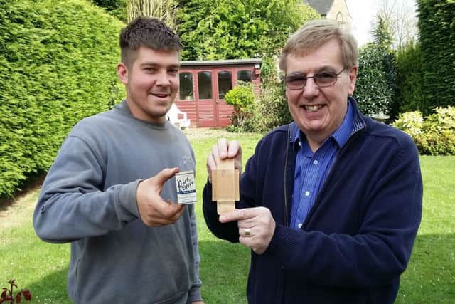 Builder Jake Burdett and Richard Sage hold a cigarette packet with was written on by builders in 1939 and left in the brickwork before being found by Jake EMN-170205-104550001